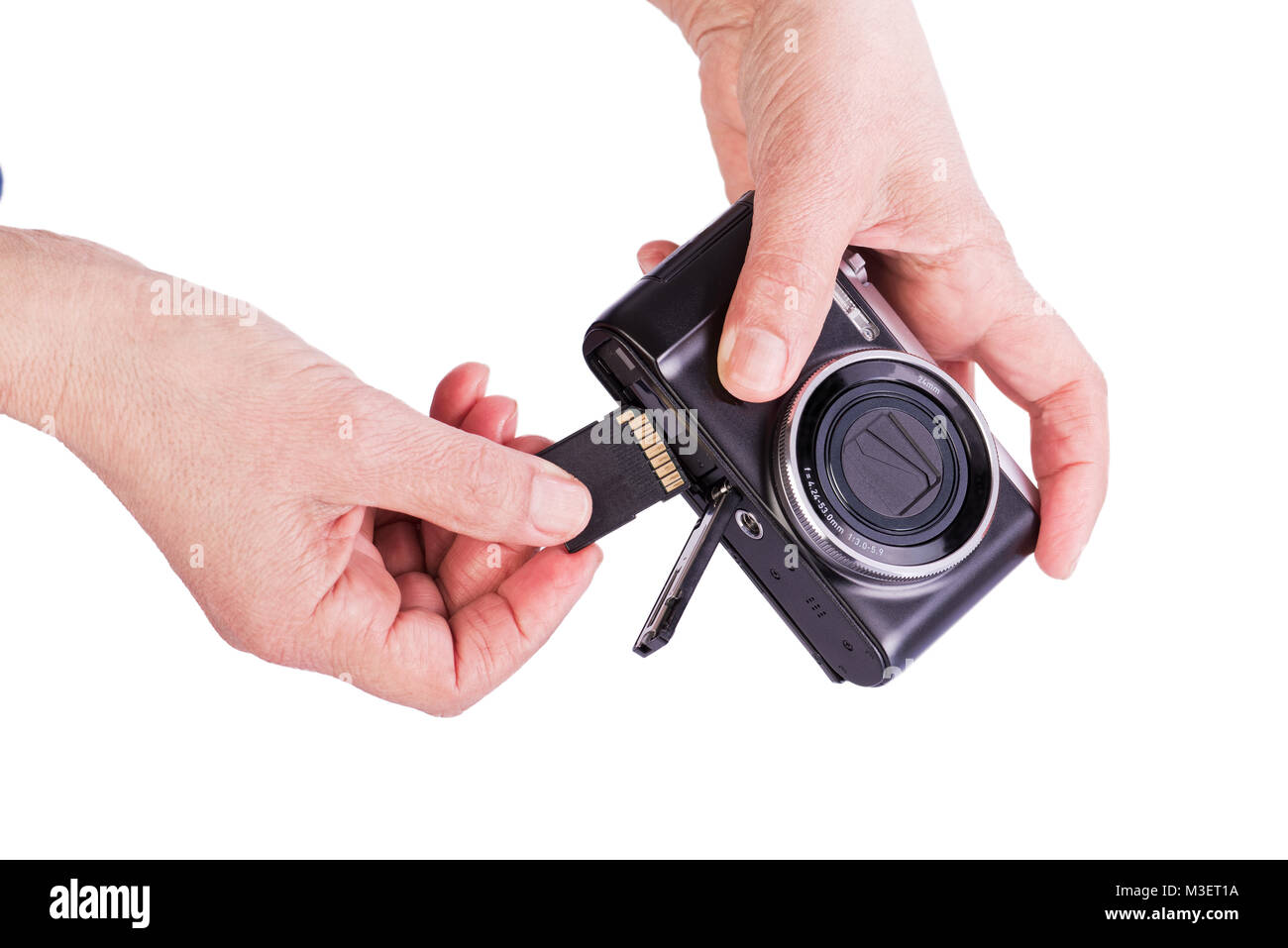 Insert memory card into the camera. Woman's hands on a white background. Stock Photo