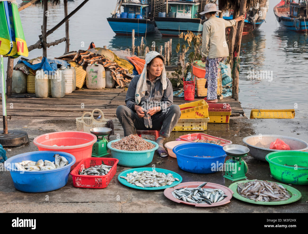 Vietnamese lady selling fish from bowls on the street by a fish market nr Hoi An Vietnam Stock Photo