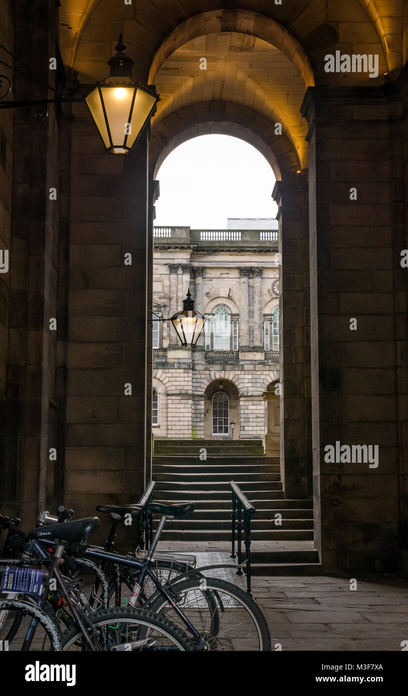 Entrance to Old College quad, South Bridge, Edinburgh, Scotland, UK, with Victorian style lamp lit up at dusk Stock Photo