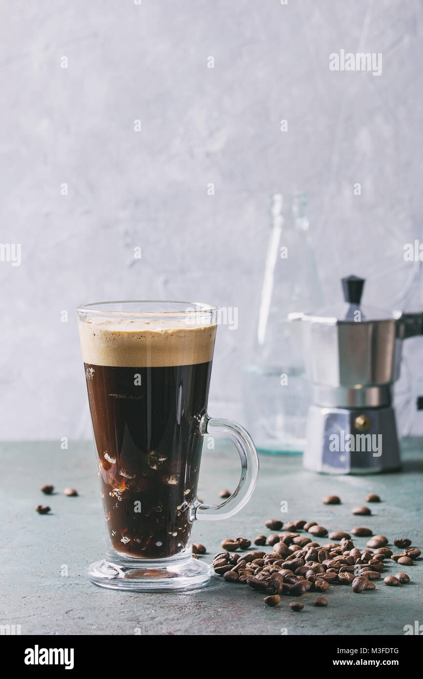Fizzy iced Coffee espresso with bottle of sparkling water, coffee maker