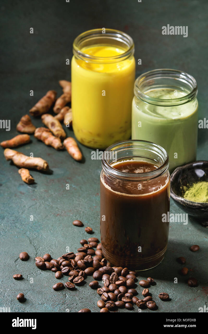 Variety of iced colorful latte drinks. Iced coffee, turmeric and matcha latte cocktails in glass