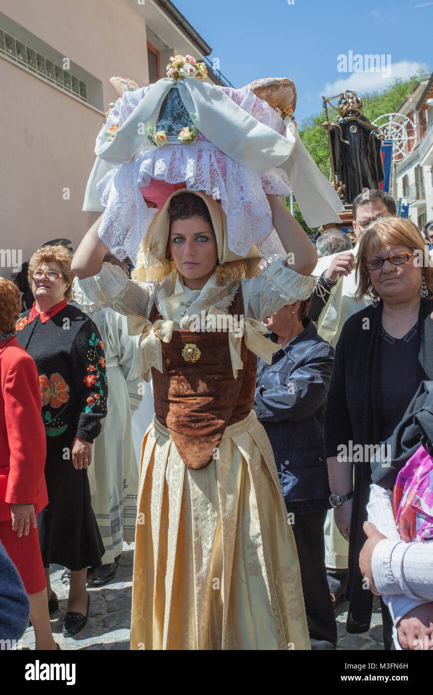 During the procession the girls of Cocullo, dressed in traditional clothes, carry on their heads wicker baskets filled with sweets typical. Abruzzo. Stock Photo