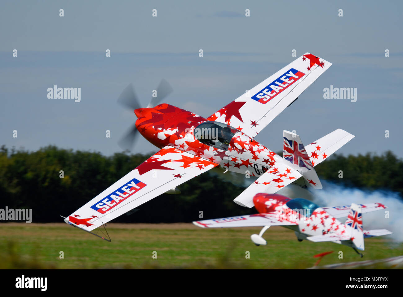 Chris Burkett flying a full size Extra plane alongside a radio control model of same plane at the Little Gransden Childen in Need airshow Stock Photo