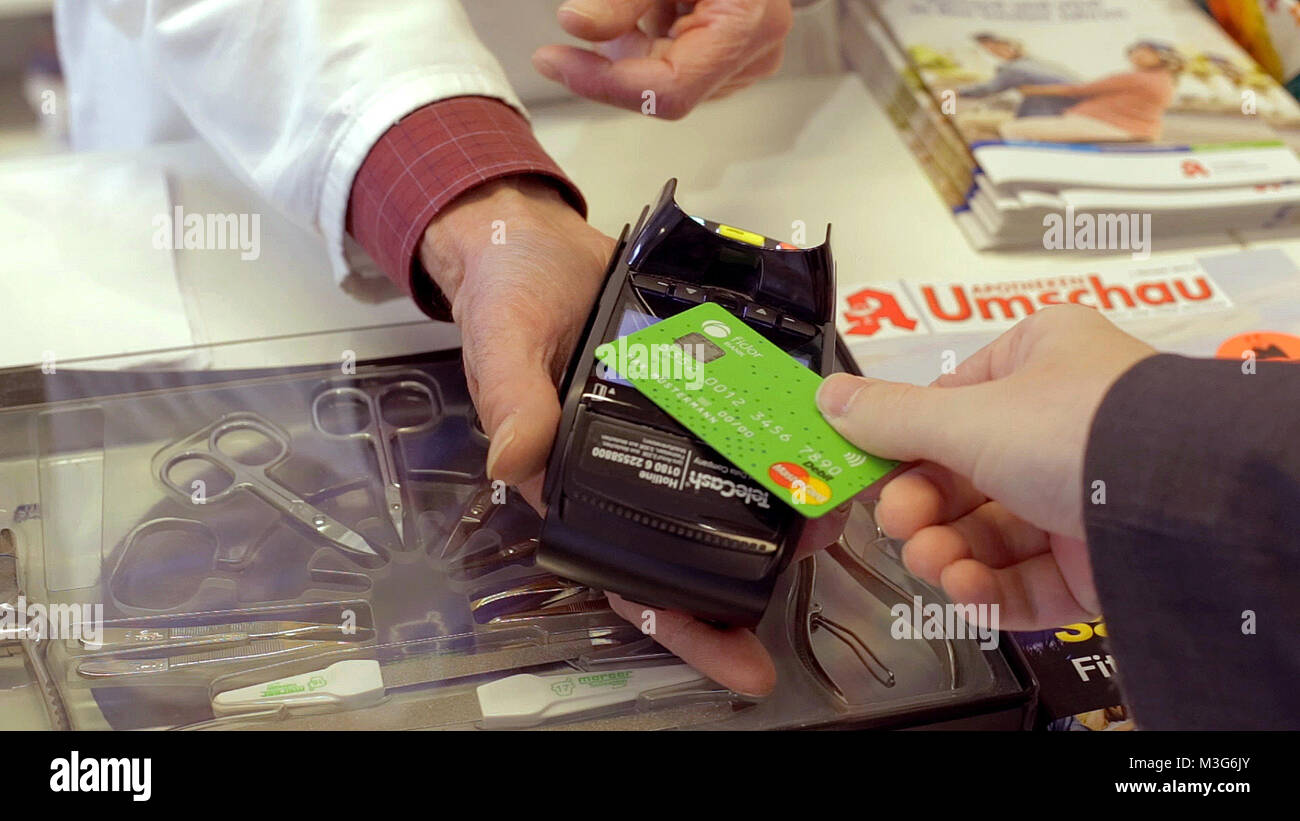 Foto einer Kontaktloszahlung mit einer grünen Debit MasterCard der Deutschen FidorBank in einer Apotheke. (Niedrige Auflösung) Stock Photo