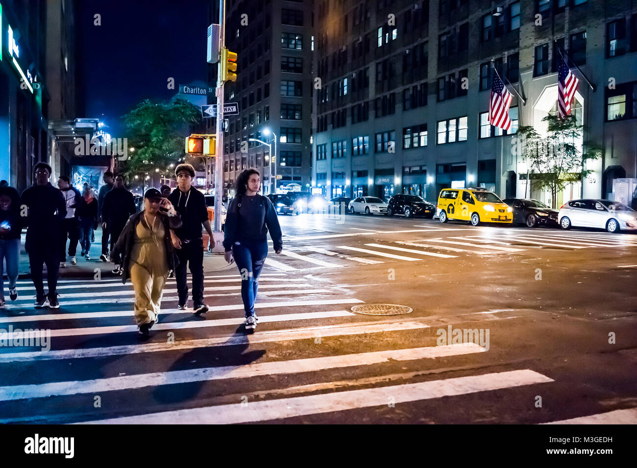 New York City, USA - October 28, 2017: NYC downtown dark evening night illuminated Charlton street road with traffic cars, people crossing sidewalk in Stock Photo