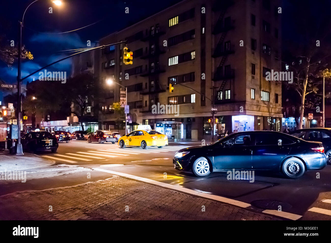 New York City, USA - October 28, 2017: NYC downtown dark evening night illuminated Charlton street road with traffic cars, taxi cab yellow in SoHo, Hu Stock Photo