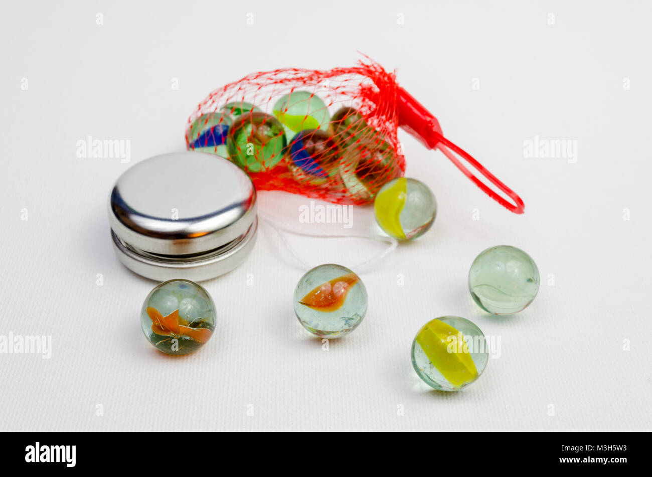 A Studio Photograph of Glass Marbles and a Silver Coloured Yoyo Stock Photo