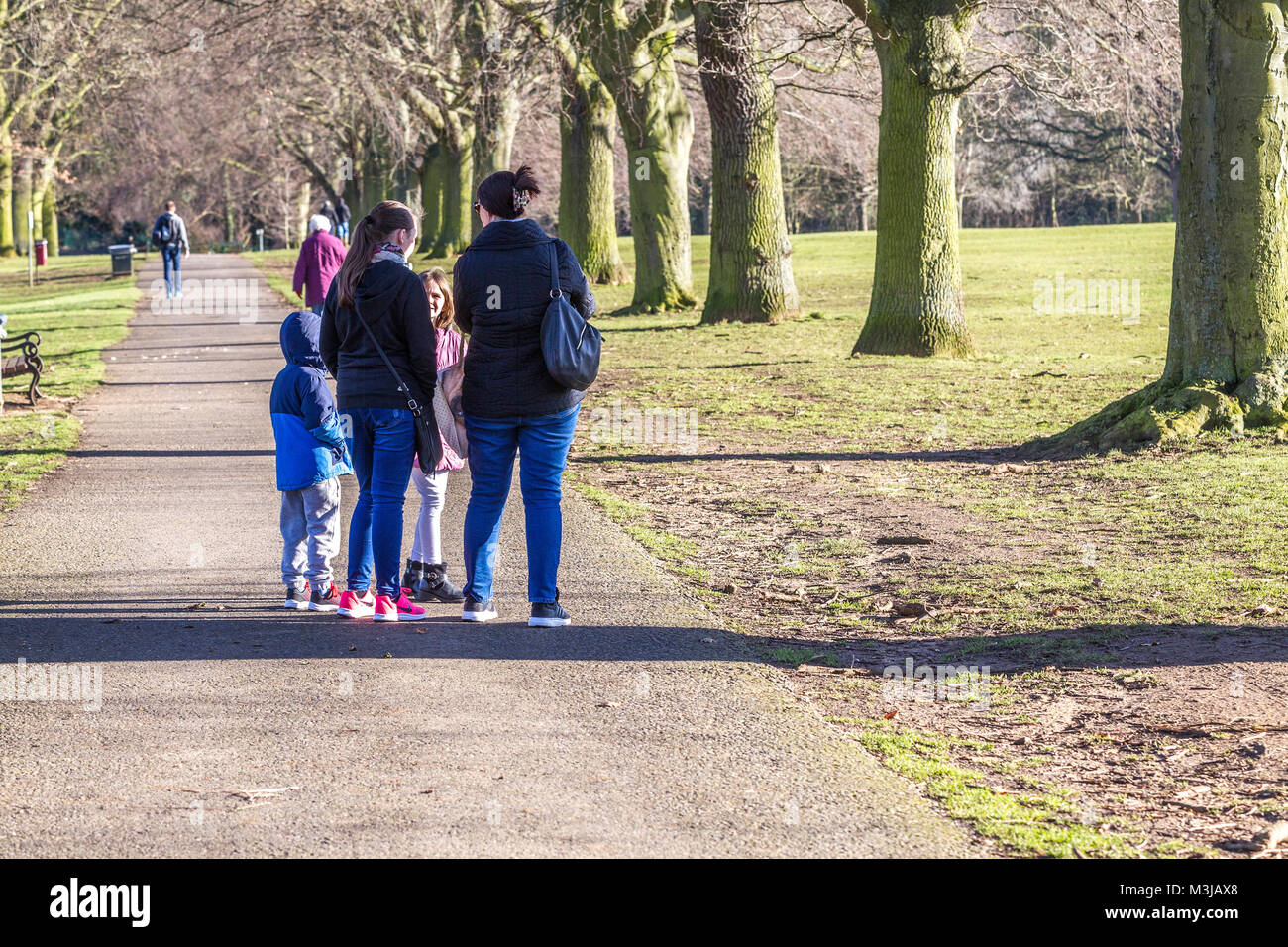 Northampton, U.K. Weather. 11th February 2018. Weather. A very cold sunny morning in Abington Park,  a family heads down towards the lake wrapped up warm to feed  the Black-headed Gulls and pigeons. Credit: Keith J Smith./Alamy Live News Stock Photo