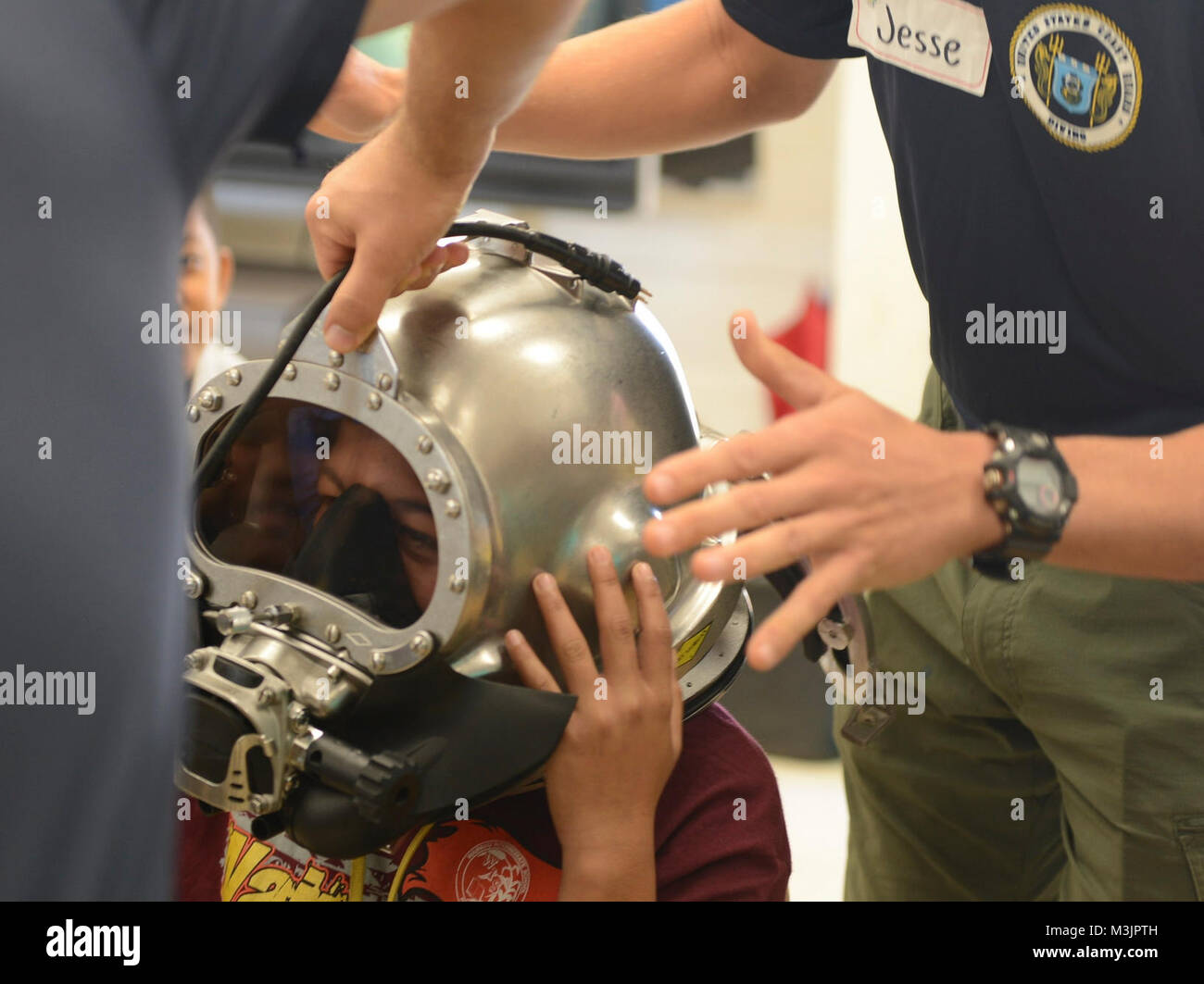 Divers from the U.S. Coast Guard Regional Dive Locker Pacific allows students to try on gear at