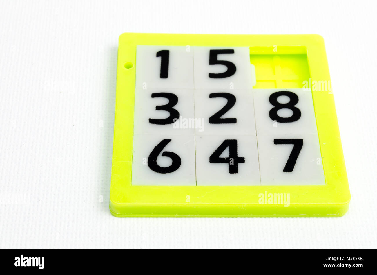 A Studio Photograph of a Yellow Plastic Slide Number Puzzle Stock Photo
