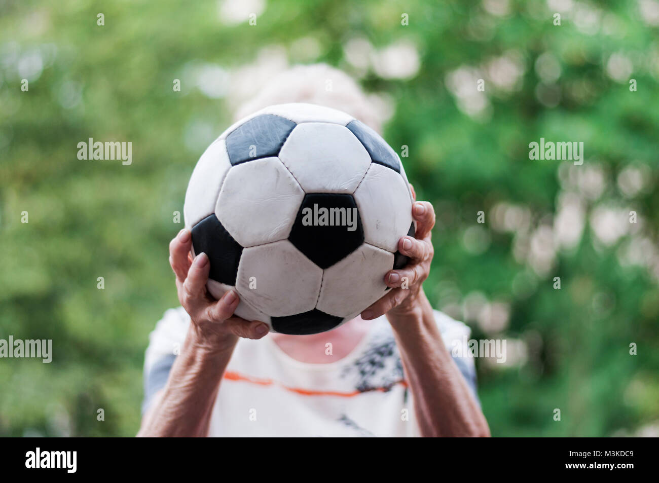 Aktive aeltere Frau faengt Fussball. Nahaufnahme von Haende und Fussball. Stock Photo