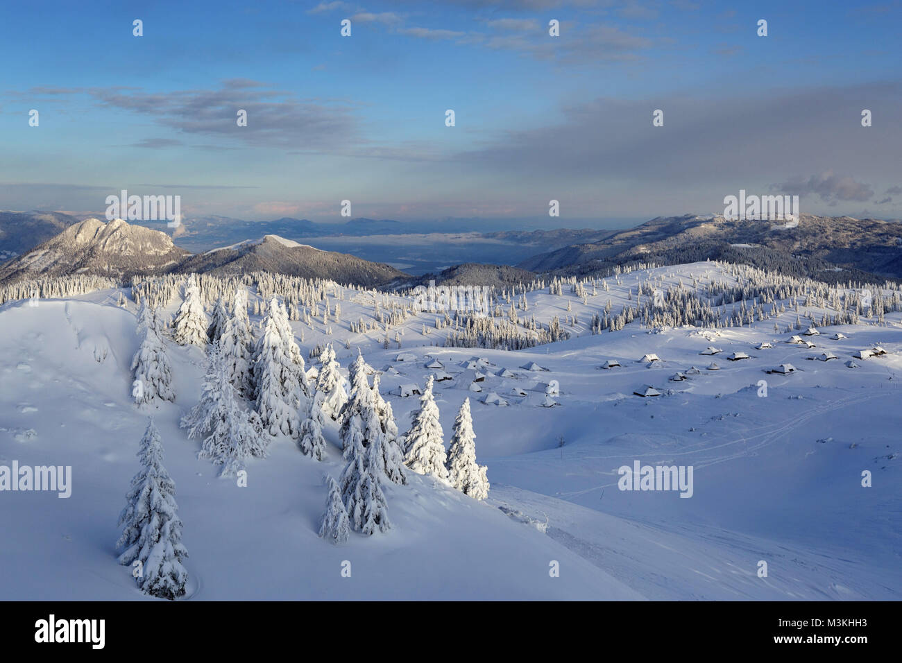Panoramic View Of Snow Covered Wooden Cabins And The Mountains And