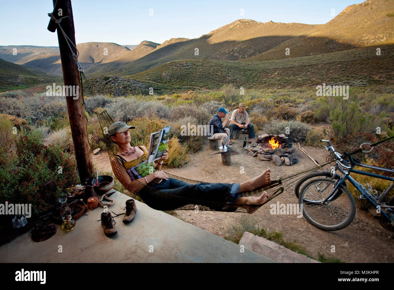 South Africa, Western Cape, Montagu, Simonskloof Mountain Retreat. Host Jurgen Wohlfarter and guests relaxing near campfire. Stock Photo