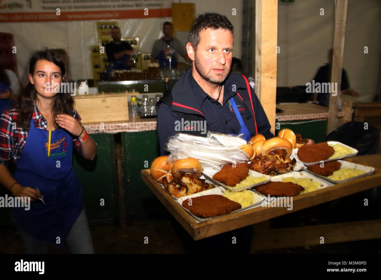Nachschub für den großen Hunger, ein Helfer serviert Schnitzel beim Kastelruther Spatzenfest 2016 Stock Photo