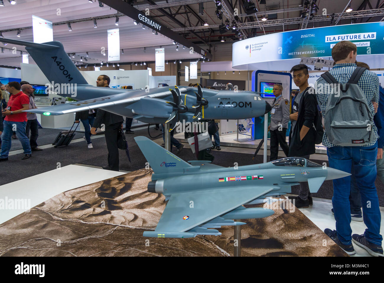 BERLIN, GERMANY - JUNE 01, 2016: The stand of Airbus Group. Models of military transport aircraft Airbus A400M Atlas and multirole fighter Eurofighter Typhoon. Exhibition ILA Berlin Air Show 2016. Stock Photo