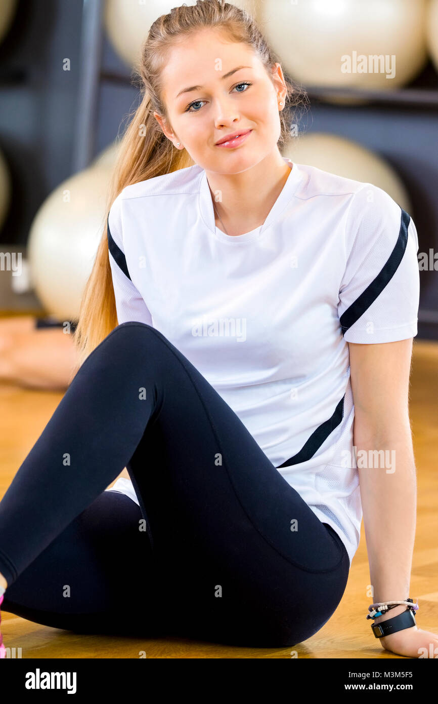 Smiling young woman in workout outfit at the fitness gym Stock