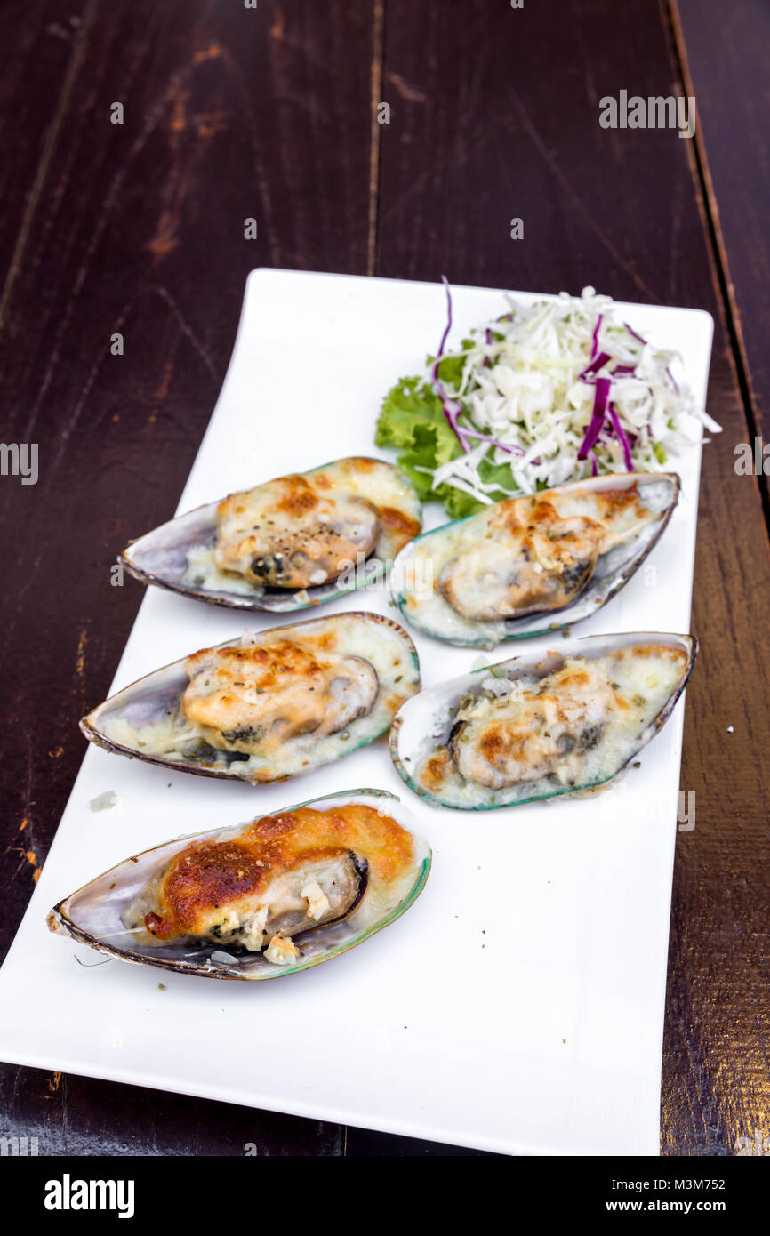 Grilled New zealand mussels with butter and garlic sauce Stock Photo
