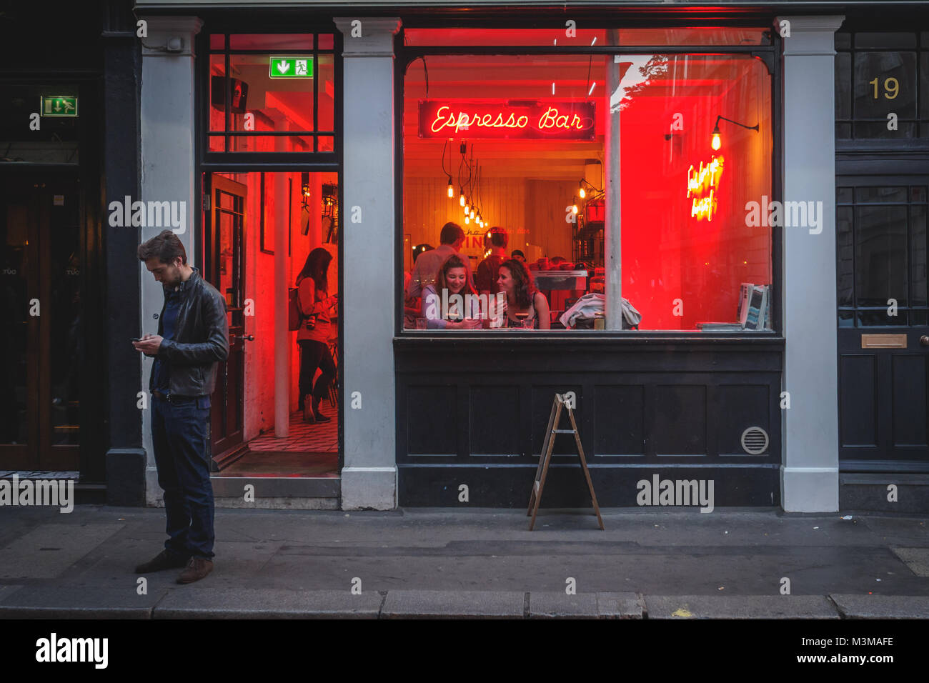 London (UK) - August 2017. People having drinks in a coffee shop in Soho. Landscape format. Stock Photo