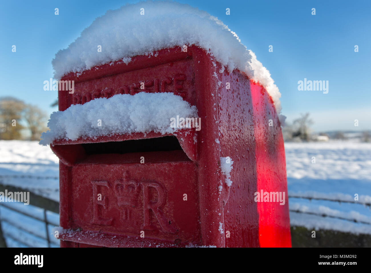 Village of Coddington, England. Picturesque winter view of a red Post