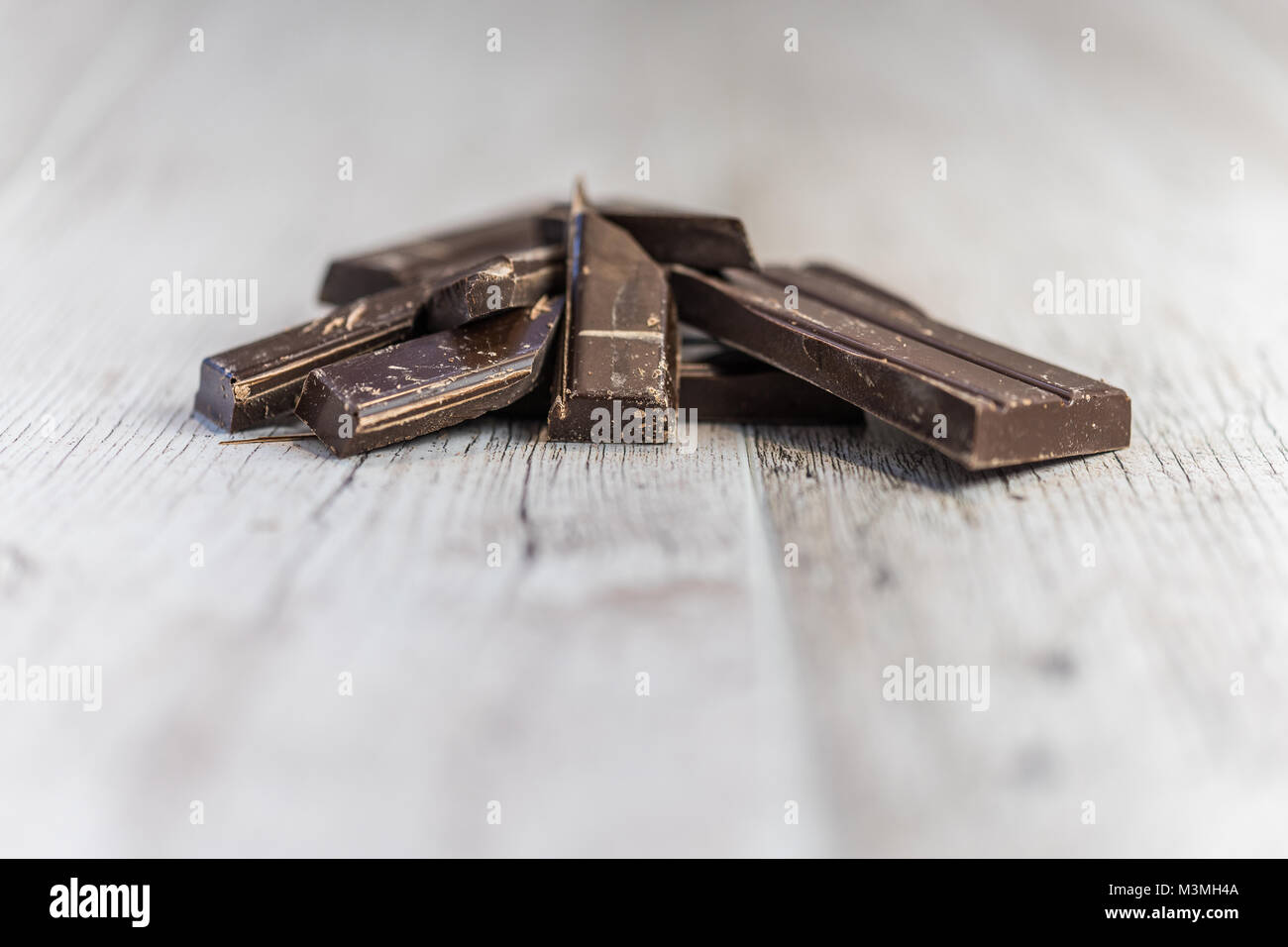 Pieces baking chocolate on wooden desk Stock Photo