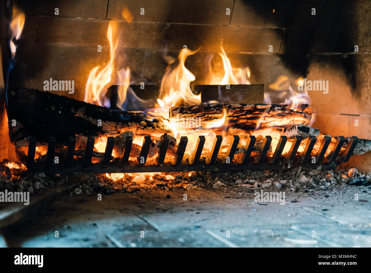Fire in the fireplace. There are burned bricks and burning wood in the