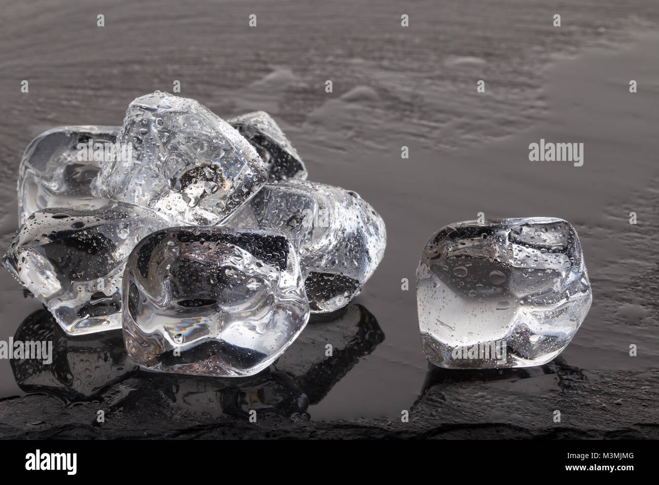 Ice cubes on black slate board with drops of water Stock Photo - Alamy