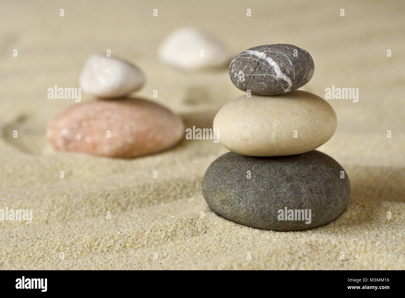 Pile of balanced stones on sand beach close-up Stock Photo
