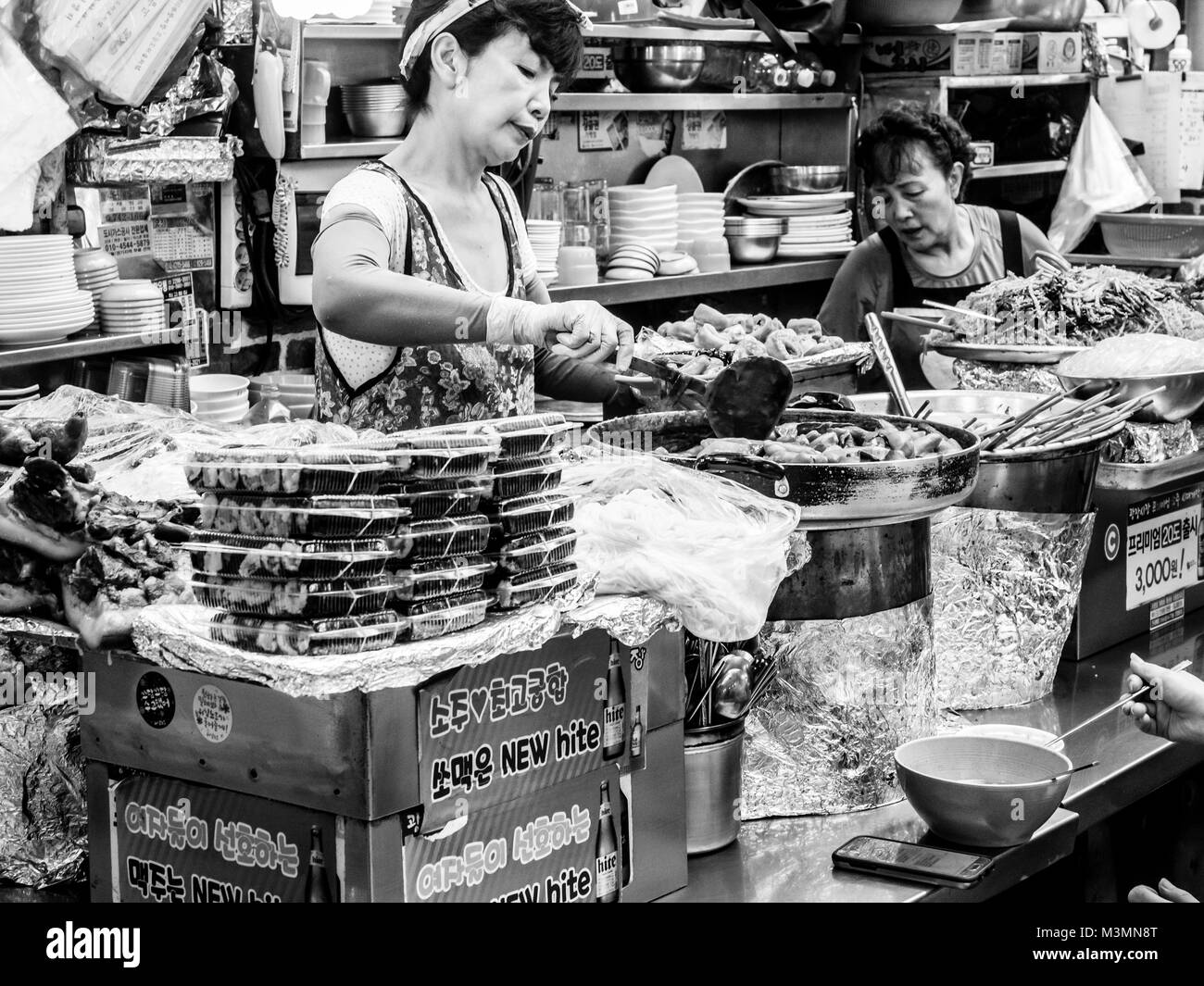 Seoul, South Korea . Woman vendor serving customers at Gwangjang Market in Seoul. Stock Photo