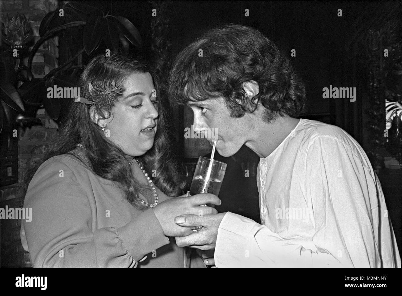 Donovan share a drink with party hostess Mama Cass Elliot at 'The Factory' in Hollywood. September 1969. 'This was taken in Los Angeles in 1969 for the launch of my album Barabajagal. I’d not long come back from India, seeing the Maharishi with the Beatles, so I was wearing my whites – Indian shirt, pantaloons and sandals'. Donovan Leitch Stock Photo