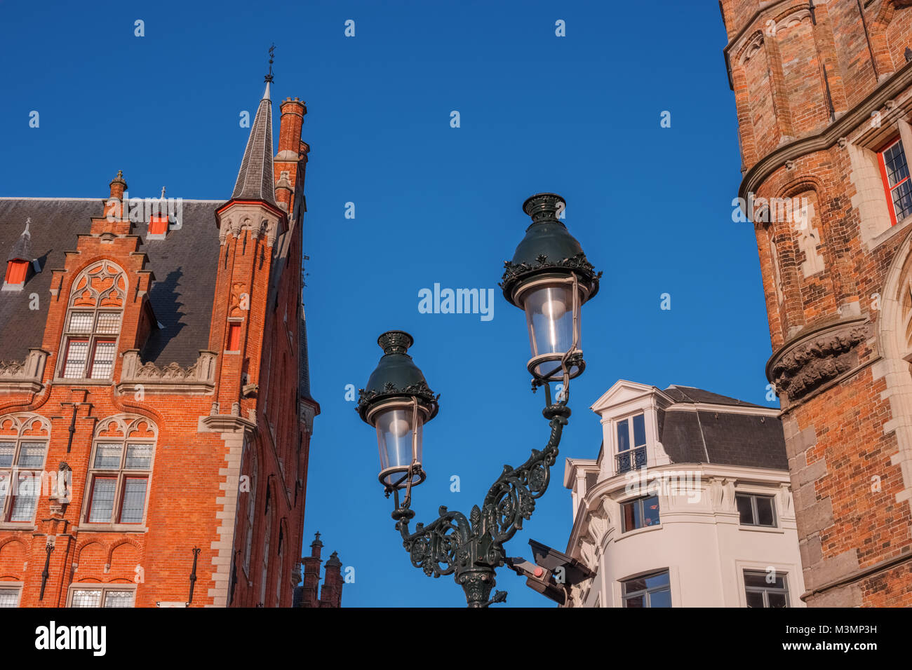 Street with old houses, lantern, Bruges, Belgium. Traditional Flemish medieval architecture in historic town centre. Brick houses in center of city. T Stock Photo
