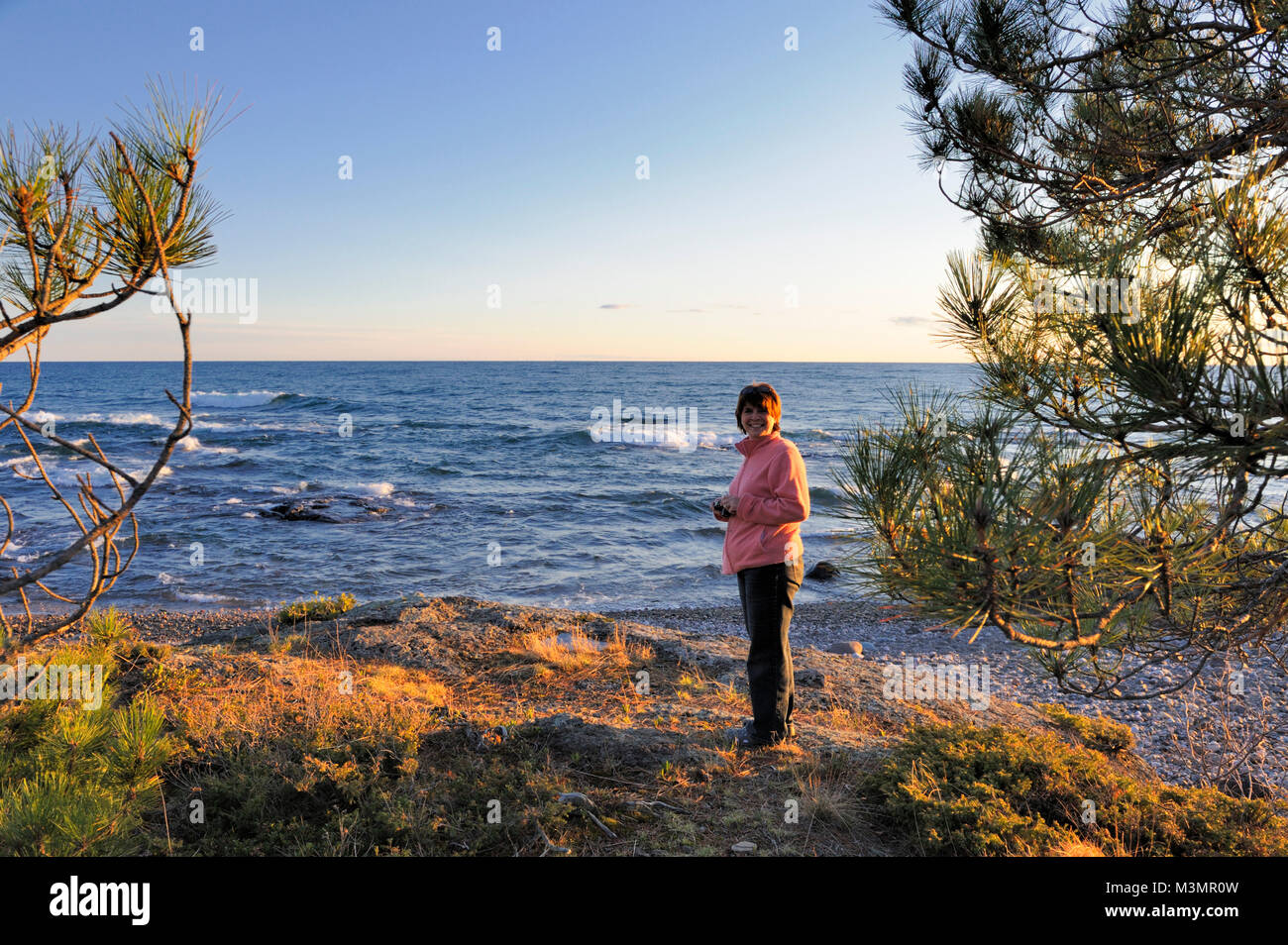 a woman smiling with her back to Bachawana bay, lake Superior Stock Photo
