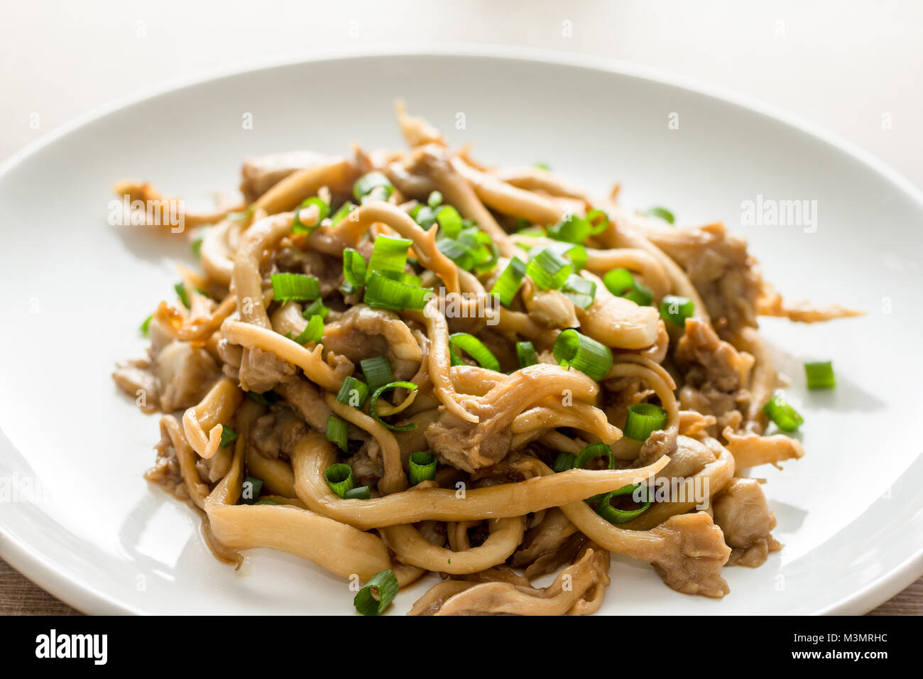 Shimeji mushroom served with chives on white plate. Typical oriental