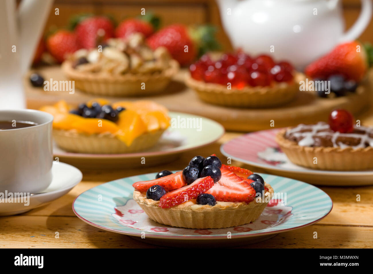 Strawberry and blueberry tart with a selection of fruit tarts in the background Stock Photo