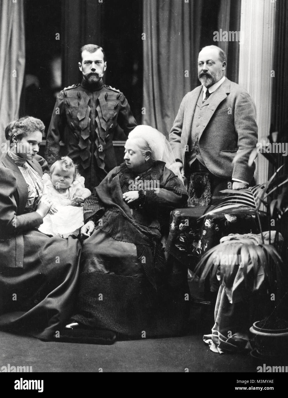 Victoria, Queen of the United Kingdom, at Balmoral Castle in Scotland, with her son Albert Edward, Prince of Wales (right), and Tsar Nicholas II of Russia (left). Seated on the left is Alexandra, Tsarina of Russia, holding her baby daughter Grand Duchess Olga. Stock Photo