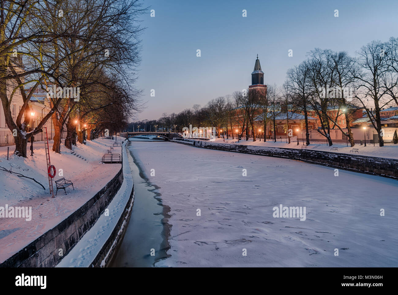 Beautiful view of Aura river at clear winter morning with street lights on and Turku Cathedral in the background Stock Photo