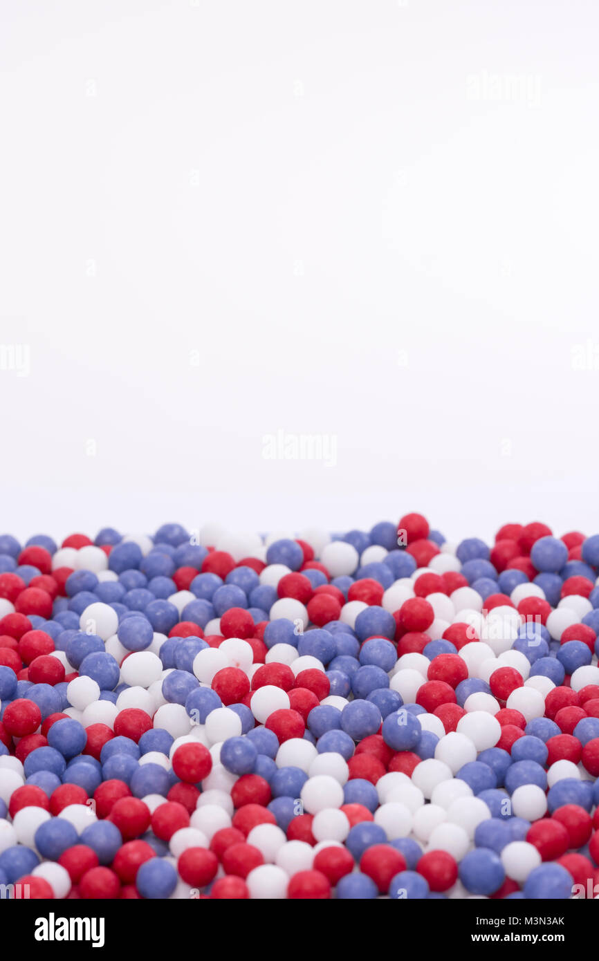Micro-photo of red, white & blue sugar pearls arrayed in random order. Also metaphor for market sectors, segmentation, Sugar Tax, EU sugar quotas. Stock Photo