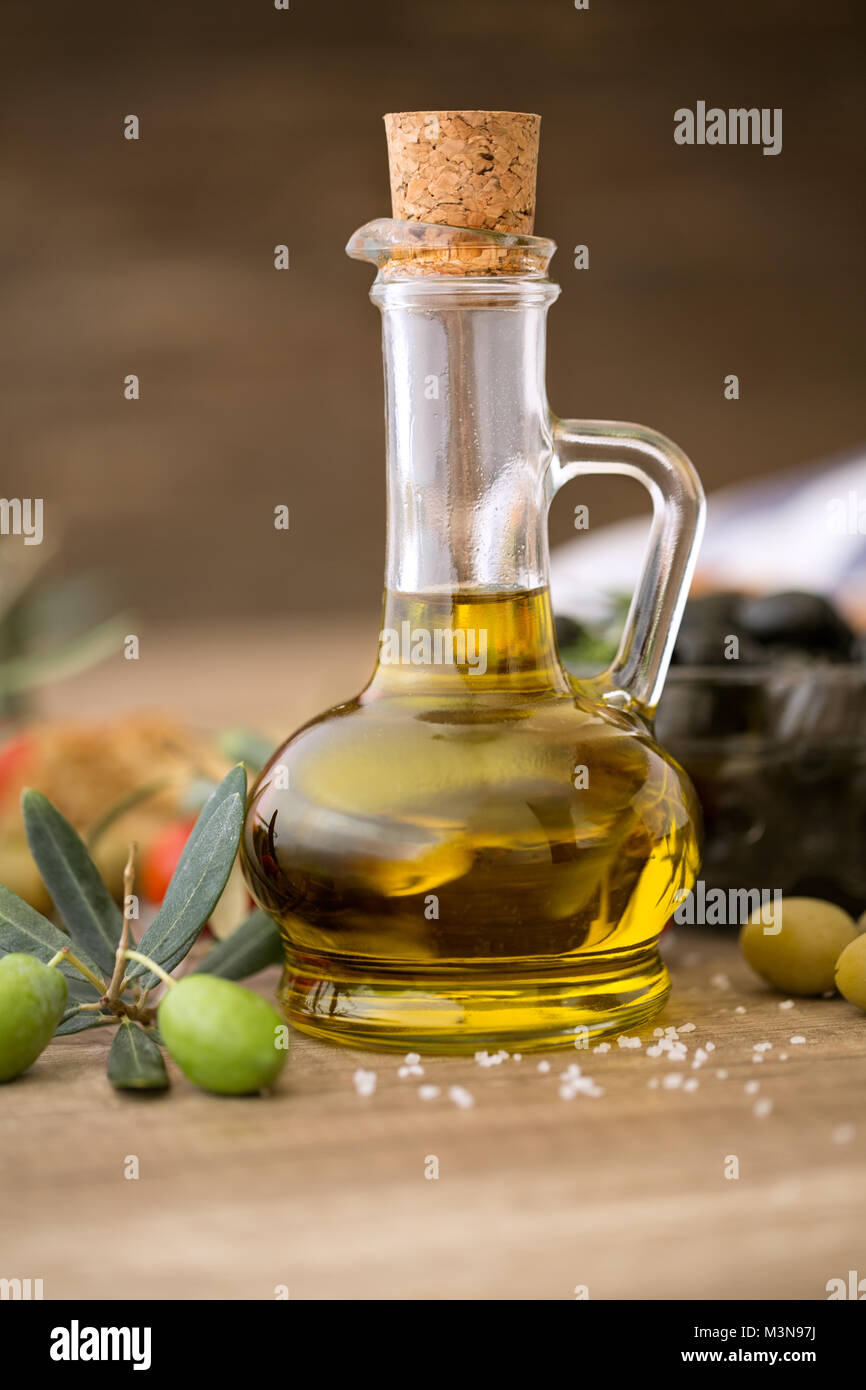 Olive oil and olive branch on the wooden table background Stock Photo ...