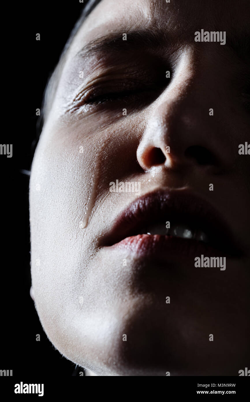 sad woman crying on black background, closeup portrait Stock Photo
