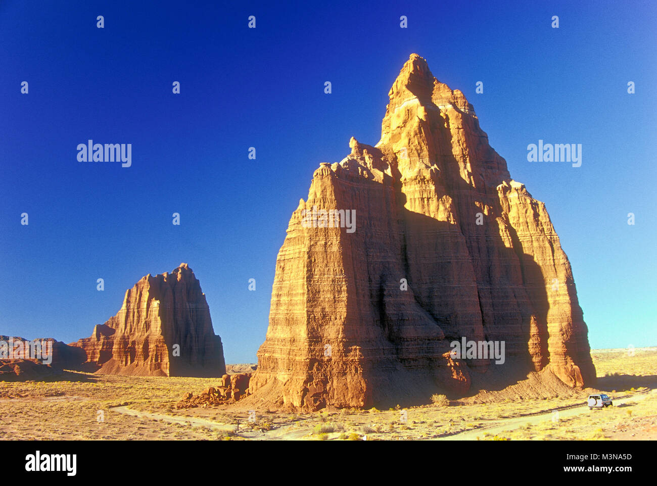 Late day's strong light illuminates the Temple of the Sun (L) and Temple of the Moon (R), monoliths in Cathedral Valley, Capitol Reef National Park, s Stock Photo
