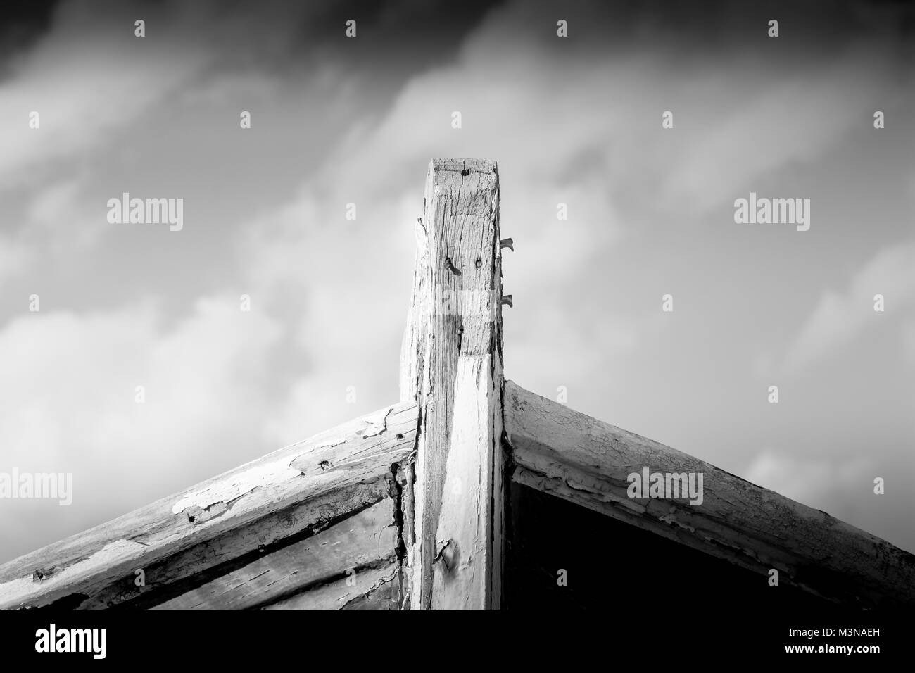 Detail of a wooden shipwreck with cloudy blue sky background. Stock Photo