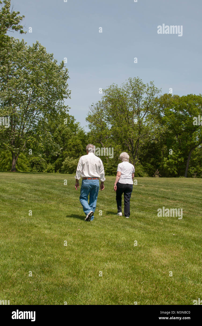 Elderly Couple Walking Through a Park Stock Photo