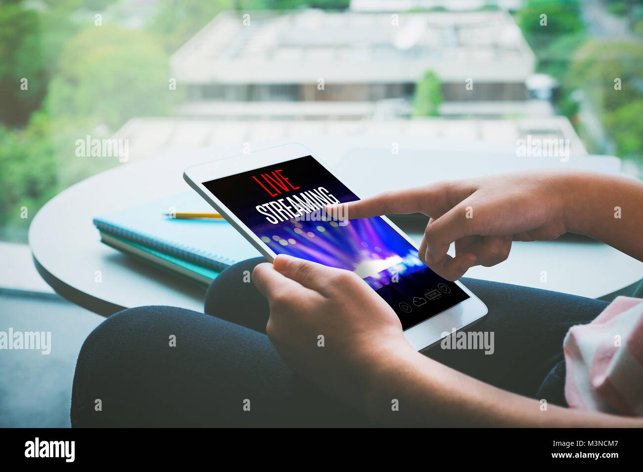 Close up hand of woman sitting watch live streaming concert on tablet at home,Digital marketing concept Stock Photo