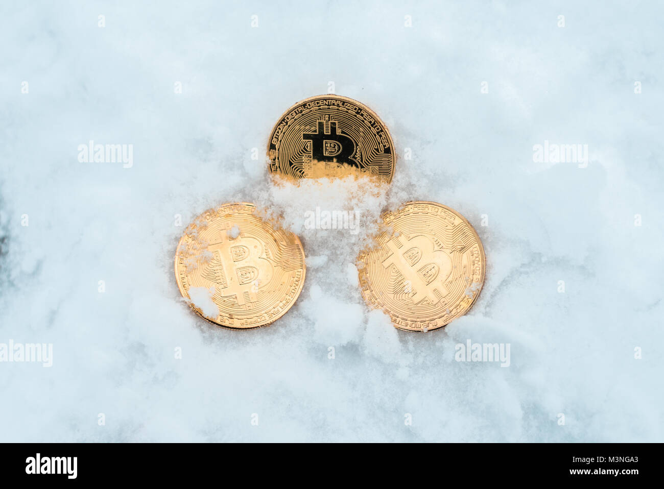 Discarded money. Metal gold coins bitcoin, crypto currency money in winter  on snow lie in snowdrift Stock Photo - Alamy