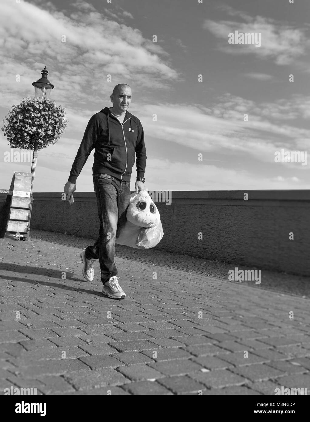 BRATISLAVA, SLOVAKIA - SEPTEMBER 26, 2017: Unrecognized man carries a strange toy over Danube river promenade. With a population of about 450 000, Bra Stock Photo