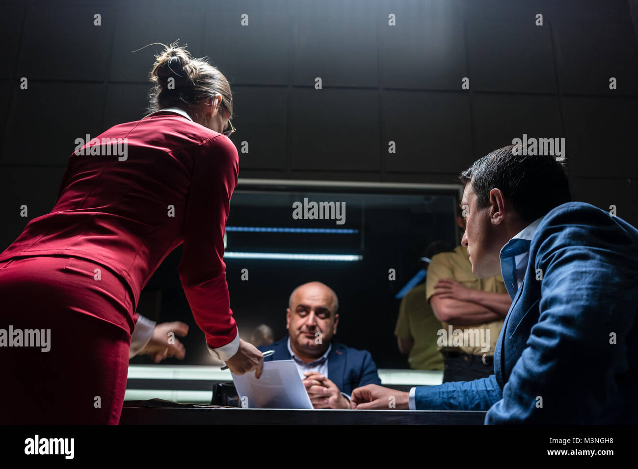 Low-angle view of a female attorney in disagreement with the prosecutor, during the preliminary hearing of an unwilling suspect in the office of a pol Stock Photo