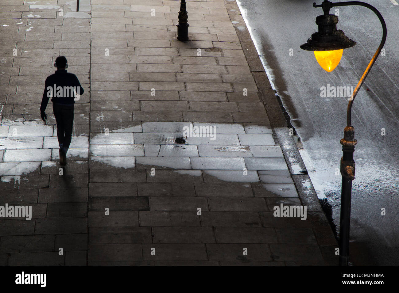 Walking under a bridge in London listening to music with headphones