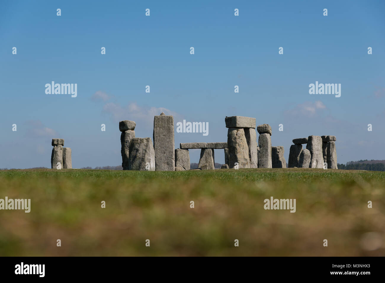 Stonehenge, Wiltshire - view across grass fields of the stone circles on a quiet day with no visitors - blurred foreground Stock Photo