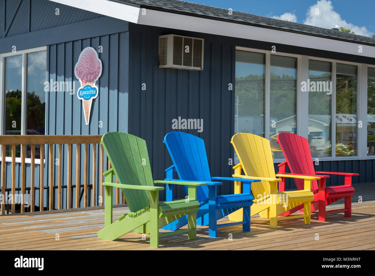 Bright primary color Adirondack chairs on outside deck concession store Georgian Bay park Parry Sound Ontario Canada pleasant sunny day WOP Stock Photo