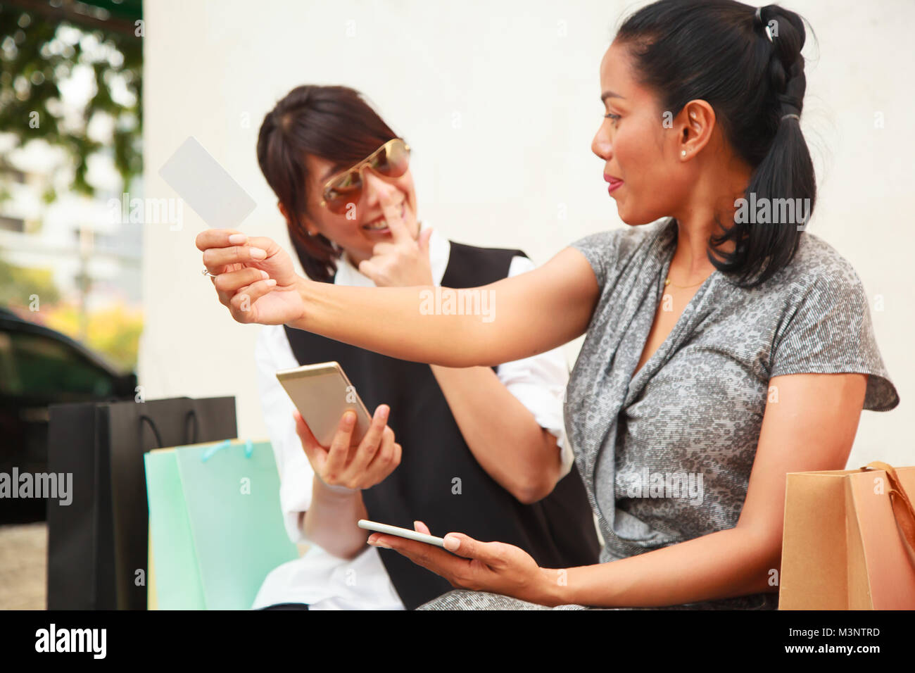 Smiling Female Ladies Shopping Concept with digital technology. Asian Buddy Female Shoppers happy shopping online with smart phone using blank credit Stock Photo Alamy