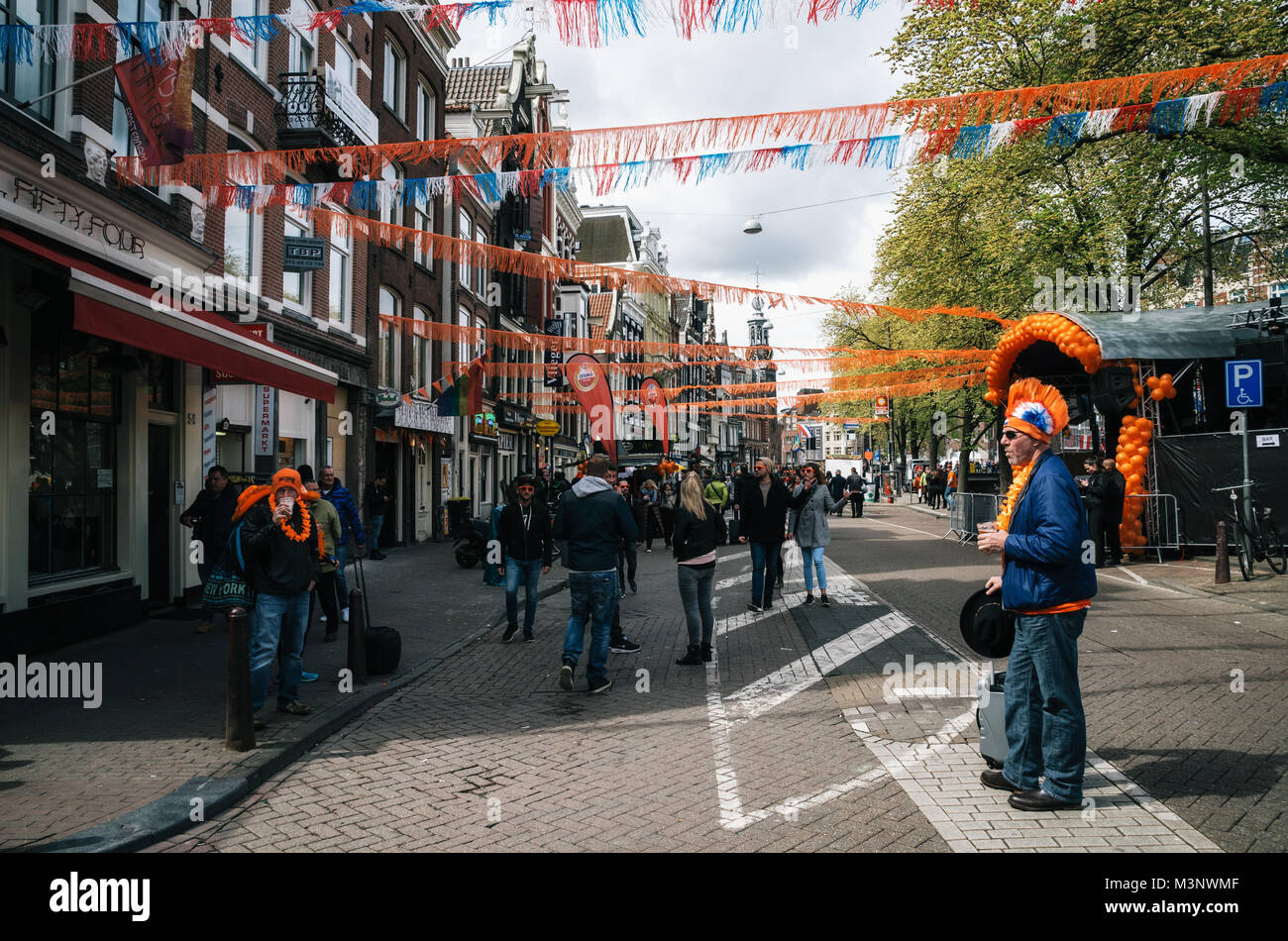 Amsterdam, Netherlands - 27 April, 2017: Streets of Amsterdam with orange decorations full of people in orange during the celebration of kings day. Ma Stock Photo